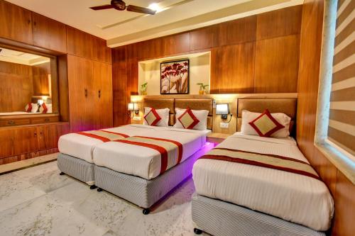 Duas camas num quarto com paredes de madeira em FabHotel Nestlay Rooms Airport em Chennai