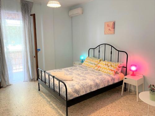 sypialnia z czarnym łóżkiem z pomarańczowymi i żółtymi poduszkami w obiekcie Olive Tree w mieście Bari