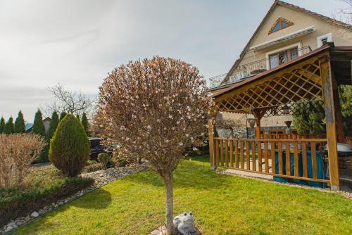 a house with a tree in the yard at Penzión Kastelán in Bojnice
