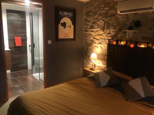 a bedroom with a bed and a stone wall at Auberge du Lac in Mandailles