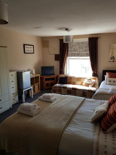 um quarto de hotel com duas camas e uma televisão em The Chase Inn em Bishops Frome