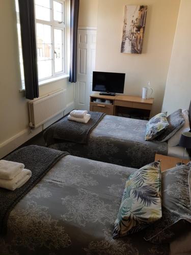 a room with three beds and a television in it at The Chase Inn in Bishops Frome