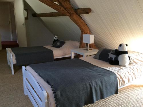 sypialnia z dwoma łóżkami z panda niedźwiedzia na nich w obiekcie Gîte Ô Beauval w mieście Saint-Aignan