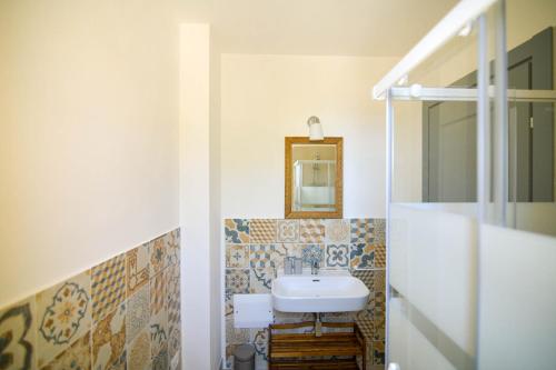 a bathroom with a sink and a mirror at LUCCICAMARE family-run BeB in Noto