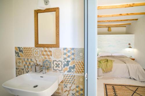 a bathroom with a sink and a bed at LUCCICAMARE family-run BeB in Noto