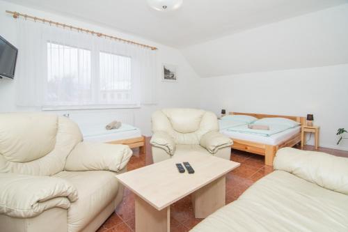 a living room with white furniture and a table at Penzion Anareta in Frýdek-Místek