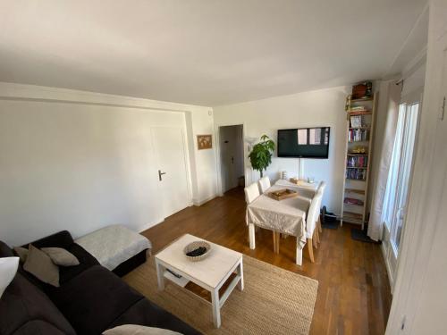 un salon avec un canapé et une table dans l'établissement Belle Appartement lumineux avec balcon plein centre ., à Caen