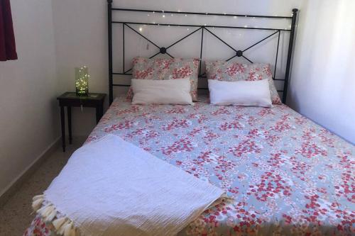 a bedroom with a bed with red and blue flowers at Casa El Castellet en Polop. in Polop