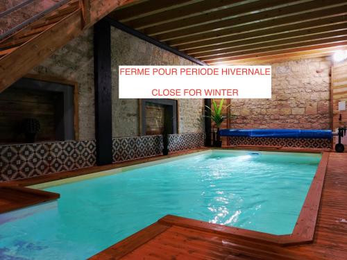 a swimming pool in a building with a sign that reads frame four fireplace influenza close at Les Prémontrés in Falaise