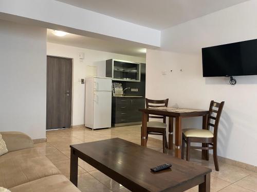 a living room with a couch and a table and a kitchen at Alexia Hotel Apartments in Ayia Napa