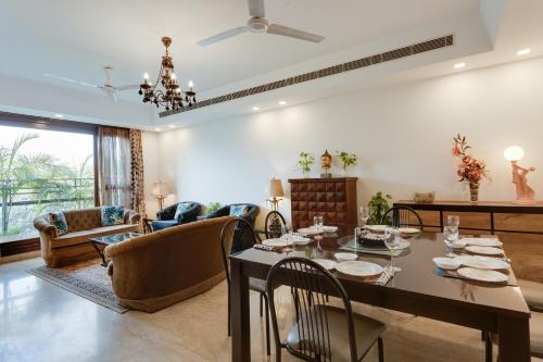 - une salle à manger et un salon avec une table et des chaises dans l'établissement Ishatvam-4 BHK Private Serviced apartment with Terrace, Anand Niketan, South Delhi, à New Delhi