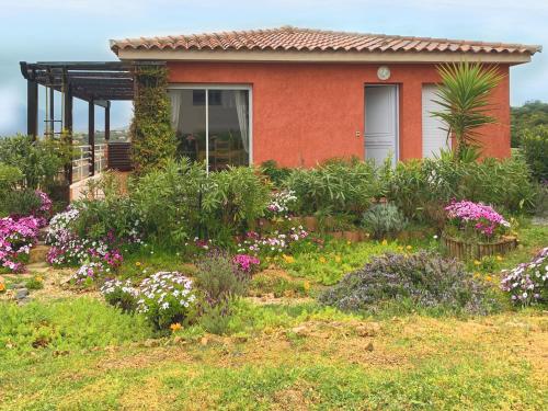 une maison avec des fleurs devant dans l'établissement MIKA DE MACHJA, à Propriano