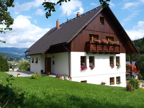 Biały dom z brązowym dachem w obiekcie Apartmány Vlasta w mieście Paseky nad Jizerou