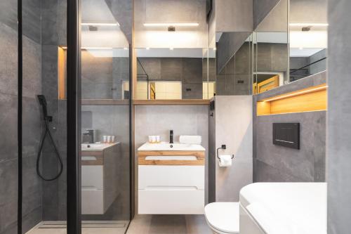 a bathroom with two sinks and a shower at Lema Apartment near Tauron Arena by Renters Prestige in Krakow