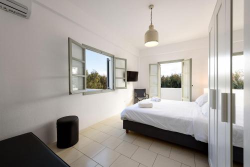 una camera bianca con un letto e due finestre di Strata Home by Rocks Estates a Kampos Paros