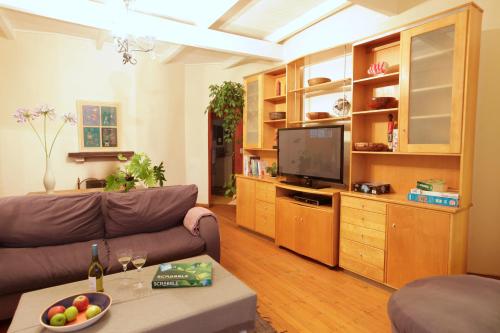 a living room with a couch and a flat screen tv at Forest Hills in Knysna