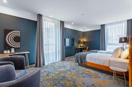 トビリシにあるTaberne Boutique Hotel Tbilisiのベッドとリビングルームが備わるホテルルームです。