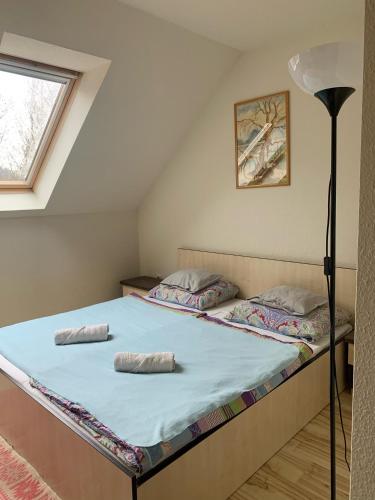 a large bed in a room with a window at Tündérszikla Panzió in Pilisjászfalu