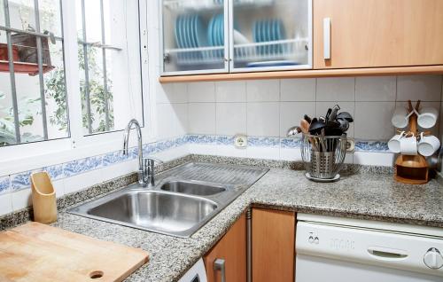 un comptoir de cuisine avec un évier et une fenêtre dans l'établissement RentalSevilla Precioso apartamento reformado en la Alameda, à Séville