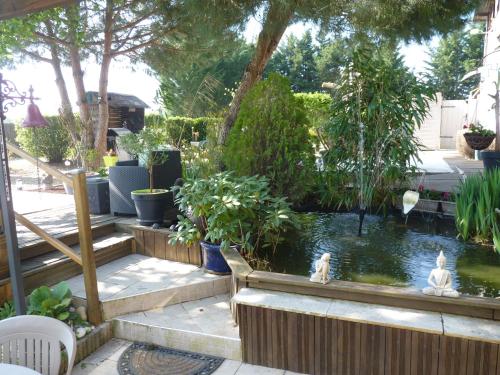a garden with a koi pond in a yard at L'arum antique in Sainte-Catherine-de-Fierbois