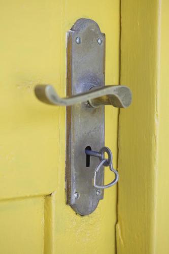 a metal door latch on a yellow door at Forest Hills in Knysna