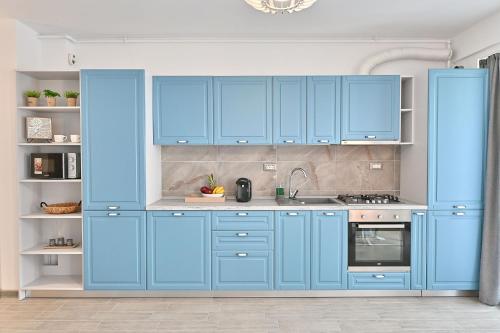 eine blaue Küche mit blauen Schränken und einer Spüle in der Unterkunft Sea Shore apartments - Spa n Pools beach resort in Mamaia
