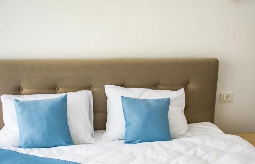 a bed with blue and white pillows on it at apart bun in Oradea