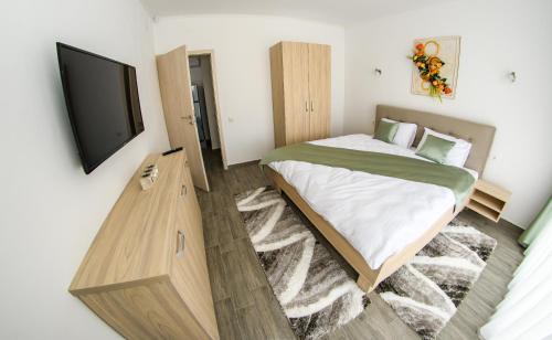 a bedroom with a bed and a flat screen tv at apart bun in Oradea