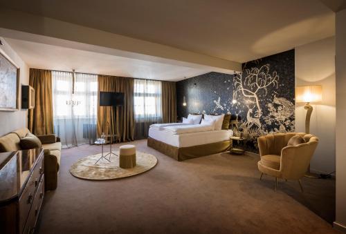 Großes Hotelzimmer mit einem Bett und einem Sofa in der Unterkunft Altstadthotel Weißes Kreuz - In der Fußgängerzone in Innsbruck