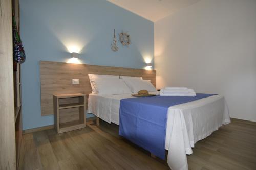 a bedroom with a bed and a table with a blue blanket at Salsedine Tropea Capo Vaticano in Santa Domenica