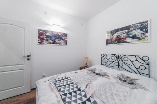 ein Schlafzimmer mit einem Bett und zwei Bildern an der Wand in der Unterkunft Sreckovic Apartmani 2 in Kragujevac