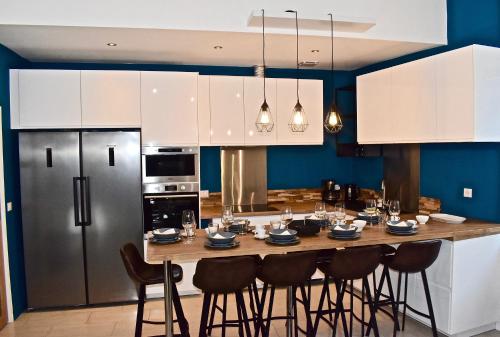 une cuisine avec une table avec des chaises et un réfrigérateur dans l'établissement COLIVING TOUT CONFORT- LOOS LES LILLE-MAISON PARTAGEE-7 chambres-5 sdb-6WC-LOOS LES LILLE, à Loos