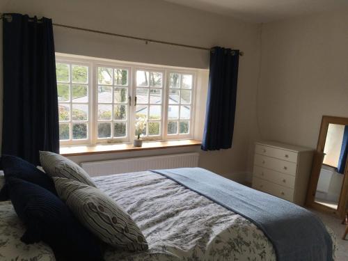 a bedroom with a bed and a window at Blue Lion Inn in Lewdown
