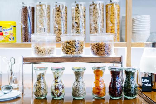 a shelf of glass vases filled with different types of nuts at Aqua Hotel in Rimini
