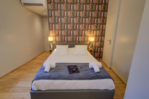 a bedroom with a large bed with two pillows at Sarlat.Catalina in Sarlat-la-Canéda