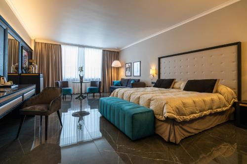 a bedroom with a large bed and a living room at Hotel Ariston in Paestum