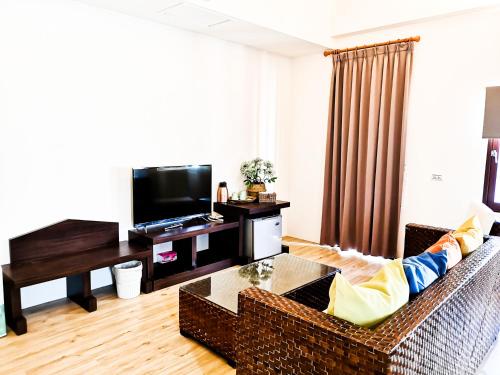 a living room with a couch and a television at Beachcastle & Sea View Villa in Magong