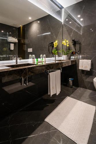 a black bathroom with a sink and a toilet at Hotel Ariston in Paestum