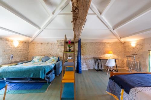 une chambre avec deux lits et une table dans l'établissement Le Cottage Bleu, à Épargnes