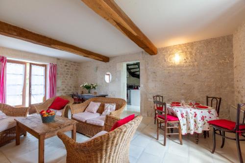 un salon avec une table et des chaises dans l'établissement Le Cottage Bleu, à Épargnes