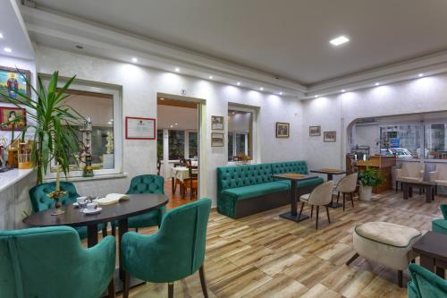 a restaurant with green furniture and tables and chairs at Konačište Dabić in Zlatibor