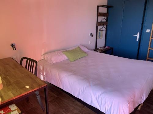 a small bedroom with a white bed and a table at Fasthotel Saint-Amand-Montrond Orval in Orval