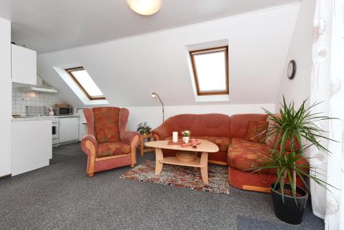 a living room with a couch and two chairs and a table at Ferienwohnungen im Haus Herrmann in Neuharlingersiel