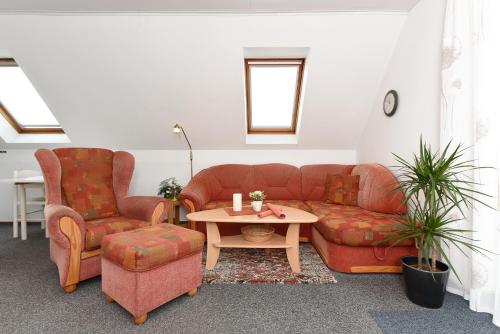 a living room with a couch and two chairs and a table at Ferienwohnungen im Haus Herrmann in Neuharlingersiel