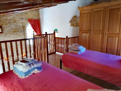 two beds in a room with pink sheets at Rock House's Villa Melody in Plataniás