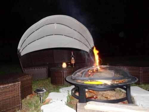 a barbecue grill with a fire in it at night at Le Clos des Mylandes in Dax