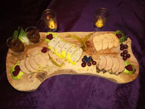 a wooden cutting board with different types of food on it at Le Clos des Mylandes in Dax