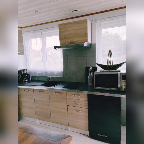 a kitchen with a black counter top and a microwave at Le Clos des Mylandes in Dax