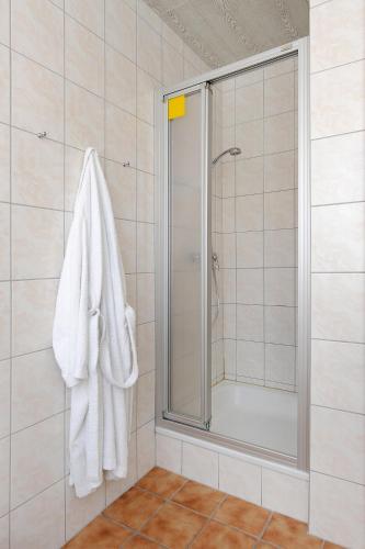 a bathroom with a shower and a white towel at Ferienwohnungen im Haus Herrmann in Neuharlingersiel