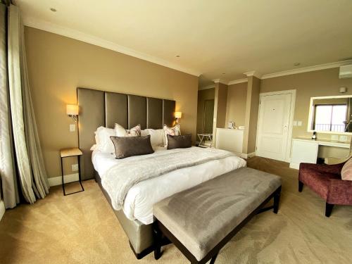 a large bedroom with a large bed and a chair at The Northcliff Boutique Hotel in Johannesburg